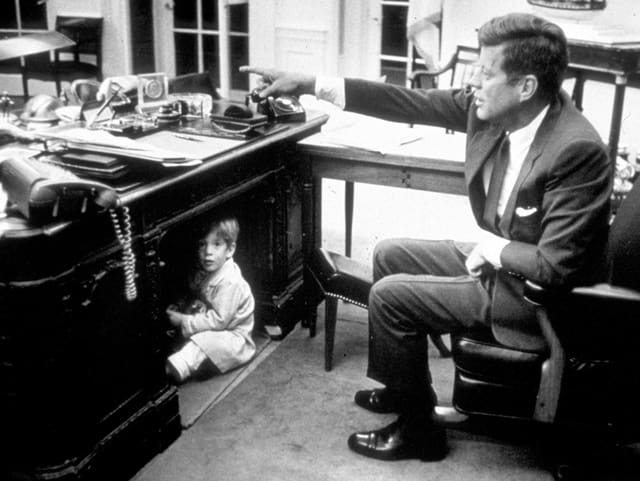 Kennedy, unter dem Tisch ein Junge Kennedy, unter dem Tisch ein Junge