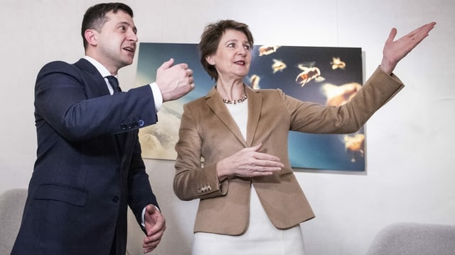 Der ukrainische Präsident und die Schweizer Bundesrätin zeigen in eine Richtung. Der ukrainische Präsident und die Schweizer Bundesrätin zeigen in eine Richtung.