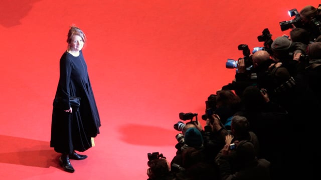 Sally Potter steht auf dem roten Teppich, dementlang die Fotografen dicht gedrängt stehen. Sally Potter steht auf dem roten Teppich, dementlang die Fotografen dicht gedrängt stehen.