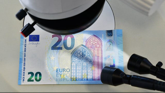 Untersuchung eines 20 Euro-Schein unter einem Mikroskop Untersuchung eines 20 Euro-Schein unter einem Mikroskop
