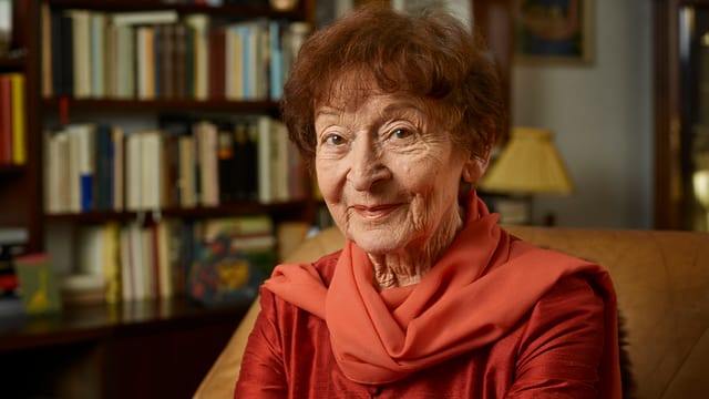 Die alte Dame sitzt in roten Farben gekleidet in einer Wohnstube Die alte Dame sitzt in roten Farben gekleidet in einer Wohnstube