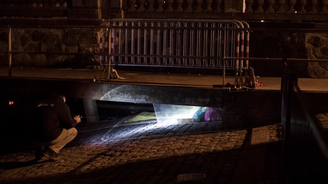 Ein Mitarbeiter der Stadt schaut in einen Schacht, um zu schauen,ob darin ein Obdachloser schläft. Ein Mitarbeiter der Stadt schaut in einen Schacht, um zu schauen,ob darin ein Obdachloser schläft.