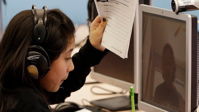 Eine junge Frau vor einem Computerbildschirm mit Webcam Eine junge Frau vor einem Computerbildschirm mit Webcam