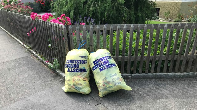Zwei Abfallsäcke mit der Aufschrift: Kunststoff-Recycling Allschwil Zwei Abfallsäcke mit der Aufschrift: Kunststoff-Recycling Allschwil