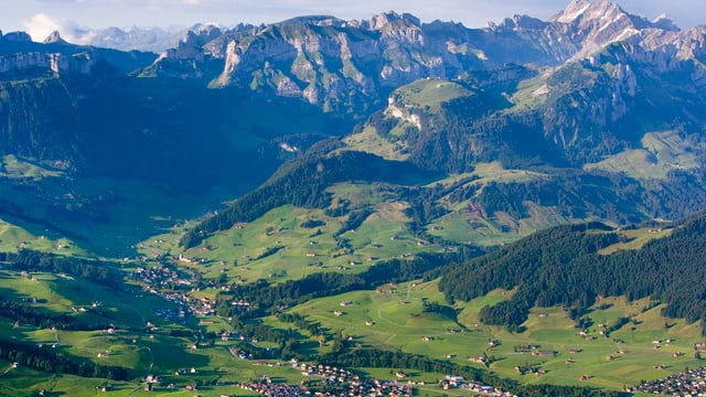Landschaftsbild Berge und Häuser und grüne Wiesen Landschaftsbild Berge und Häuser und grüne Wiesen