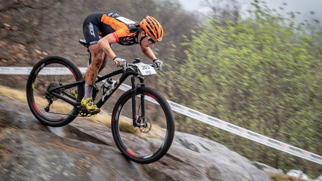 Frau fährt mit Mountainbike über Felsen Frau fährt mit Mountainbike über Felsen