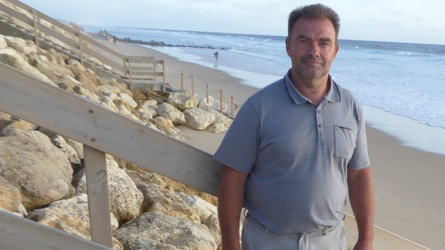 Ein Mann steht am Strand Ein Mann steht am Strand