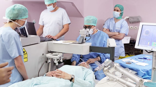 In einem Spital wird eine Person am Auge operiert. In einem Spital wird eine Person am Auge operiert.