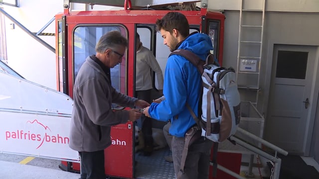 Besucher steigen in die Seilbahn ein. Besucher steigen in die Seilbahn ein.
