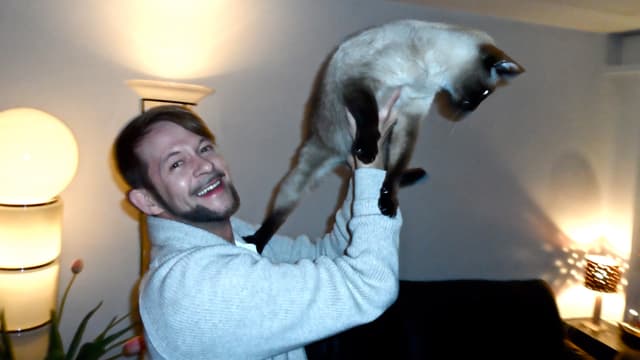 Michael von der Heide mit seinem Siamkater Sämi Michael von der Heide mit seinem Siamkater Sämi