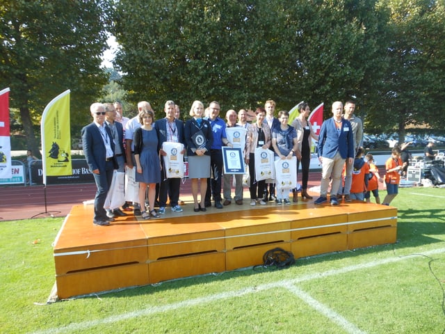 Das Organisationsteam, ca. 12 Personen, steht auf einem Podest Das Organisationsteam, ca. 12 Personen, steht auf einem Podest