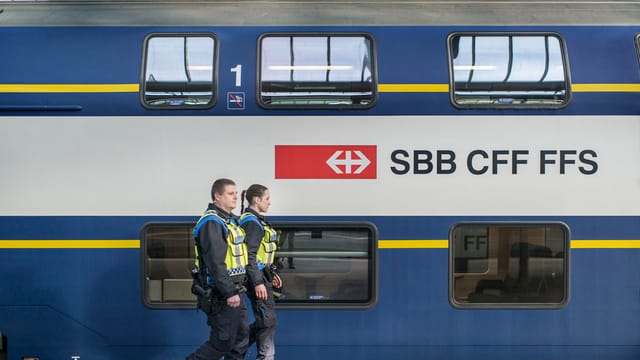 tren cun il logo da SBB CFF FFS e duas persunas da la polizia tren cun il logo da SBB CFF FFS e duas persunas da la polizia