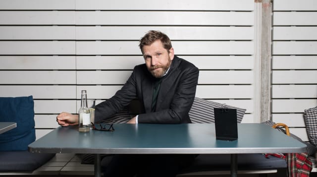 Streiff sitz im Anzug an einem Tisch. Streiff sitz im Anzug an einem Tisch.