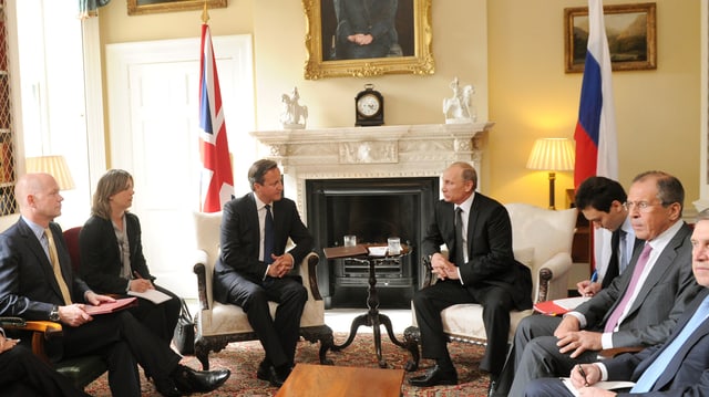 Putin und Cameron sitzend vor einem Kamin. Putin und Cameron sitzend vor einem Kamin.