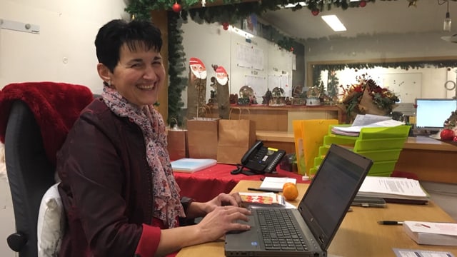 Die neue Präsidentin der St. Niklausgesellschaft, ein Frau mit dunkeln, kurzen Haaren sitzt hinter einen Laptop und lächelt in die Kamera. Das Foto wurde im Samichlausbunker aufgenommen. Die neue Präsidentin der St. Niklausgesellschaft, ein Frau mit dunkeln, kurzen Haaren sitzt hinter einen Laptop und lächelt in die Kamera. Das Foto wurde im Samichlausbunker aufgenommen.