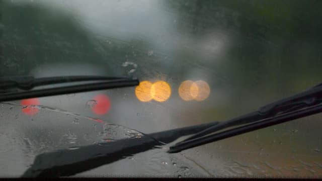 Scheibenwischer an der Frontscheibe eines Autos an einem verregneten Tag. Scheibenwischer an der Frontscheibe eines Autos an einem verregneten Tag.