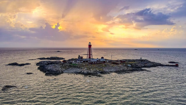 Einsame Insel im Sonnenuntergang mit Leuchturm und Haus Einsame Insel im Sonnenuntergang mit Leuchturm und Haus