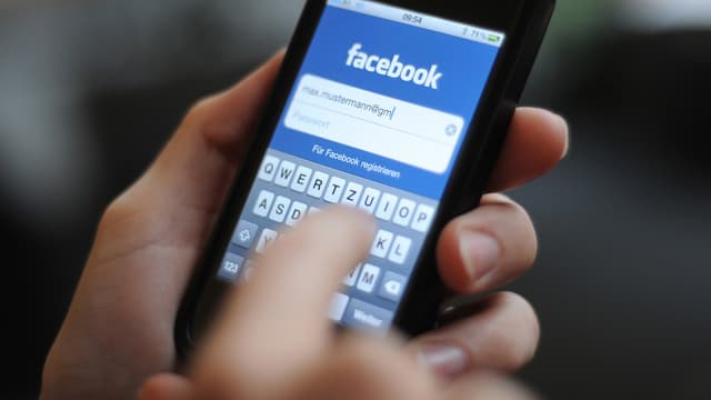 Ein Nutzer logt sich über sein Smartphone auf Facebook ein. Ein Nutzer logt sich über sein Smartphone auf Facebook ein.