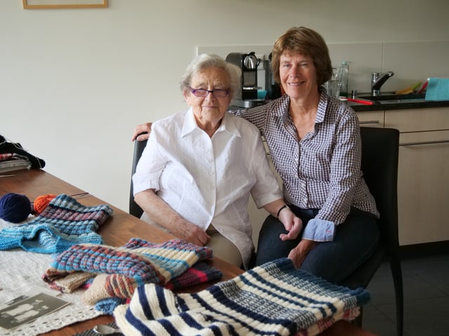 Zwei Frauen an einem Esstisch mit Strickarbeiten. Zwei Frauen an einem Esstisch mit Strickarbeiten.