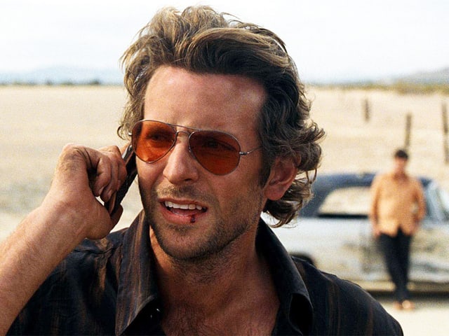 Bradley Cooper am Telefon in der Wüste. Bradley Cooper am Telefon in der Wüste.