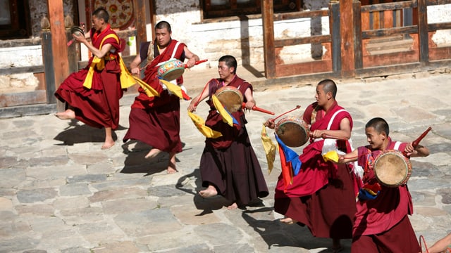 Männer in buddhistischer Kleidung mit Trommeln Männer in buddhistischer Kleidung mit Trommeln