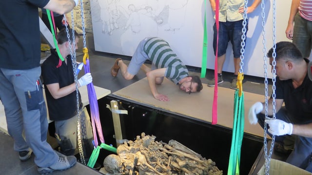 Ein jungsteinzeitliches Grab wird in eine Vertiefung im Boden gelegt. Ein jungsteinzeitliches Grab wird in eine Vertiefung im Boden gelegt.