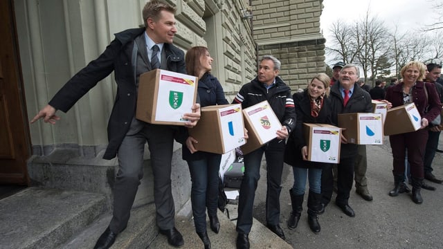 SVP-Präsident Toni Brunner und weitere Aktivisten reichen sich Schachteln mit Unterschriften weiter. SVP-Präsident Toni Brunner und weitere Aktivisten reichen sich Schachteln mit Unterschriften weiter.