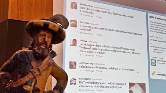 Leinwand mit Twitter-Nachrichten, davor eine Statue. Leinwand mit Twitter-Nachrichten, davor eine Statue.