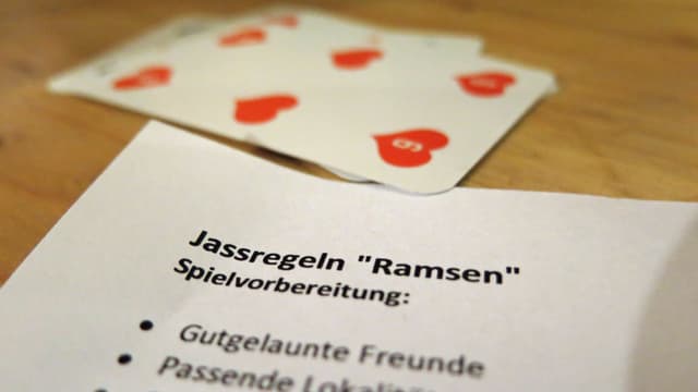 Jasskarten und ein Regelblatt auf einem Tisch. Jasskarten und ein Regelblatt auf einem Tisch.