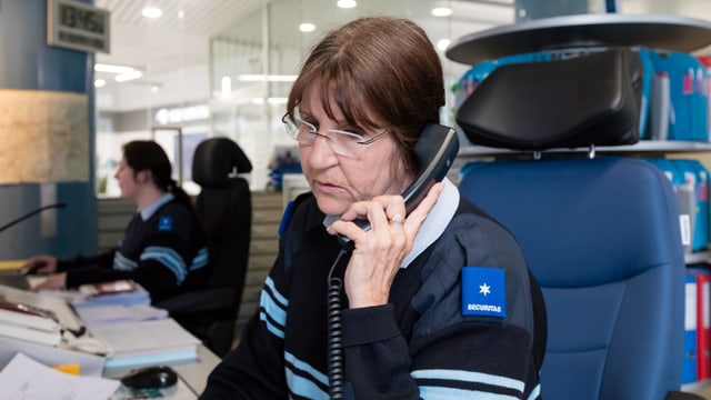 Eine Frau in Securitas-Uniform telefoniert. Eine Frau in Securitas-Uniform telefoniert.