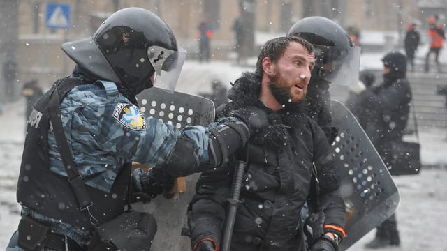 Polizisten verhaften einen Demonstranten in Kiew zurück. Polizisten verhaften einen Demonstranten in Kiew zurück.