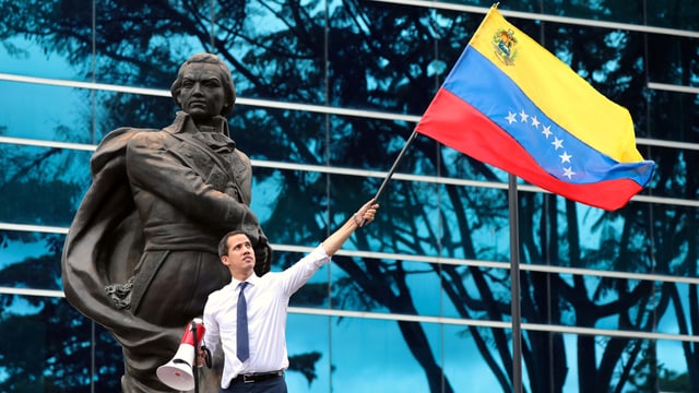 Juan Guaidó schwenkt eine venezolanische Fahne Juan Guaidó schwenkt eine venezolanische Fahne