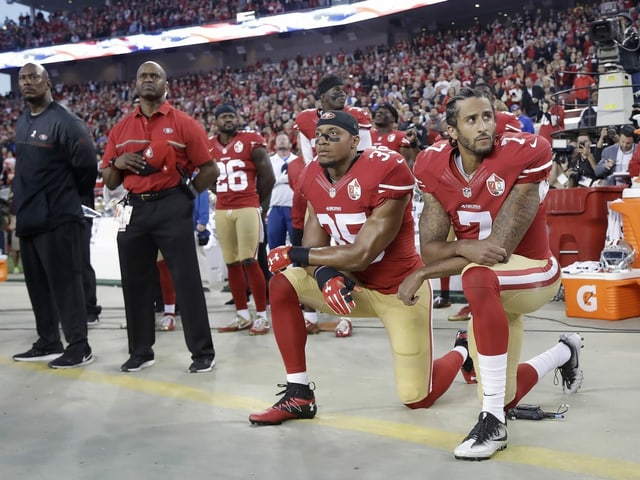 Colin Kaepernick (r.) kniet zusammen mit Teamkollege Eric Reed. Colin Kaepernick (r.) kniet zusammen mit Teamkollege Eric Reed.