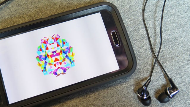 Der Screen eines Smartphones mit einem farbigen Bild. Daneben liegen Kopfhörer. Der Screen eines Smartphones mit einem farbigen Bild. Daneben liegen Kopfhörer.