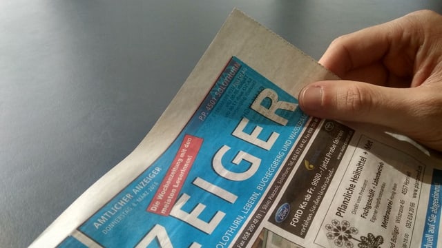 Eine Person blättert im Anzeiger der Stadt Solothurn Eine Person blättert im Anzeiger der Stadt Solothurn