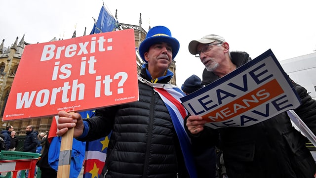 Zwei Männer mit zwei Plakaten pro und kontra den Brexit. Zwei Männer mit zwei Plakaten pro und kontra den Brexit.