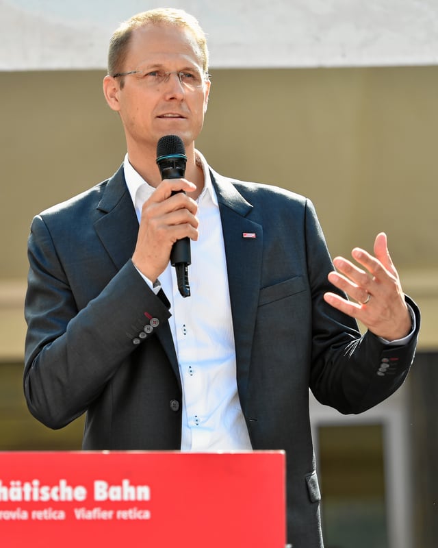 Renato Fasciati, directur da la Viafier retica avant in pult da pledar. En ses maun dretg tegna el in microfon. Renato Fasciati, directur da la Viafier retica avant in pult da pledar. En ses maun dretg tegna el in microfon.