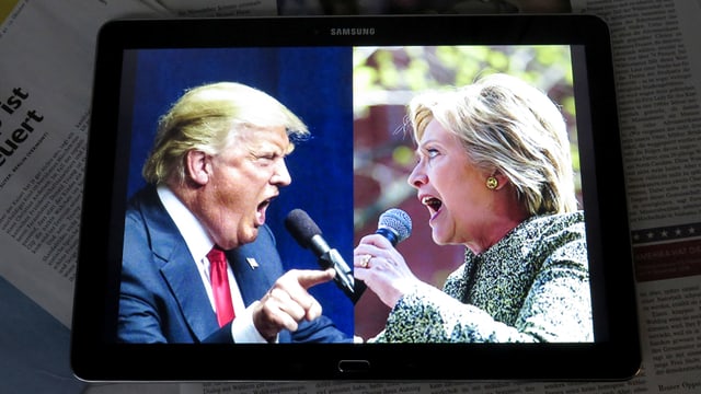 Ein Tablet-Computer mit Porträts von Donald Trump und Hillary Clinton auf dem Screen.