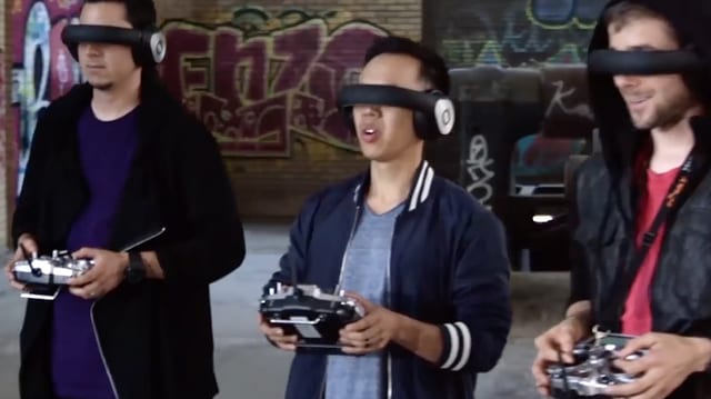 Drei junge Männer, stehend, jeder mit Videobrille und Fernbedienung für die Drohne. Drei junge Männer, stehend, jeder mit Videobrille und Fernbedienung für die Drohne.