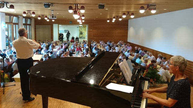 Roland Capeder dirigia e Lucretia Bärtsch accumpogna ils veterans durant il chant communabel. Roland Capeder dirigia e Lucretia Bärtsch accumpogna ils veterans durant il chant communabel.