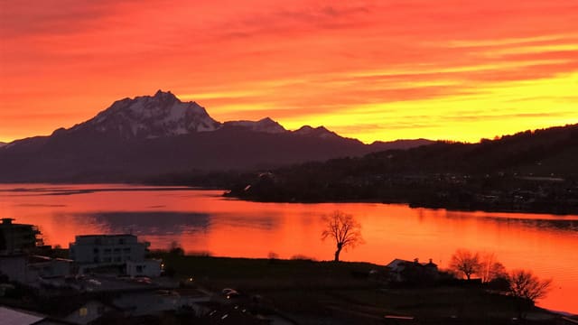 Blick von Küssnach an der Rigi über den orangen Vierwaldstättersee zum Pilatus und zum rot-goldenen Abendrot. Blick von Küssnach an der Rigi über den orangen Vierwaldstättersee zum Pilatus und zum rot-goldenen Abendrot.