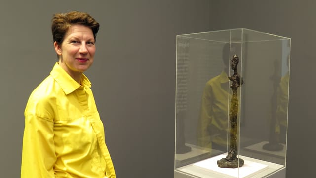 Eine Frau steht neben einer Skulptur. Eine Frau steht neben einer Skulptur.