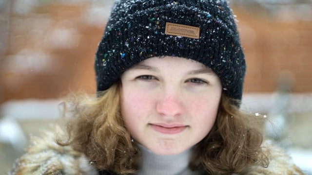 Junge Frau mit orangen schulterlangen Haaren mit schwarzer Mütze Junge Frau mit orangen schulterlangen Haaren mit schwarzer Mütze