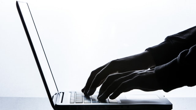 Ein Mann tippt auf eine Laptop-Tastatur Ein Mann tippt auf eine Laptop-Tastatur