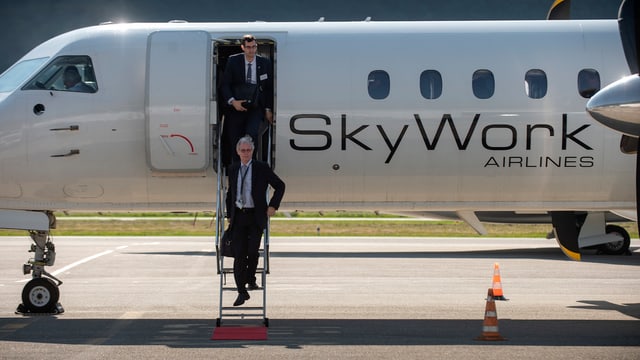 Flugzeug, zwei Personen steigen aus Flugzeug, zwei Personen steigen aus