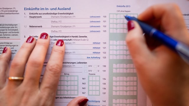 Zwei Hände und ein Stift über Steuerunterlagen. Zwei Hände und ein Stift über Steuerunterlagen.