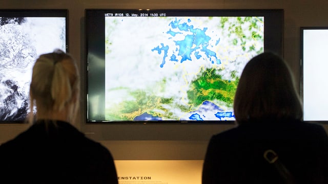 Zwei Frauen schauen Meteo-Bildschirm an. Zwei Frauen schauen Meteo-Bildschirm an.