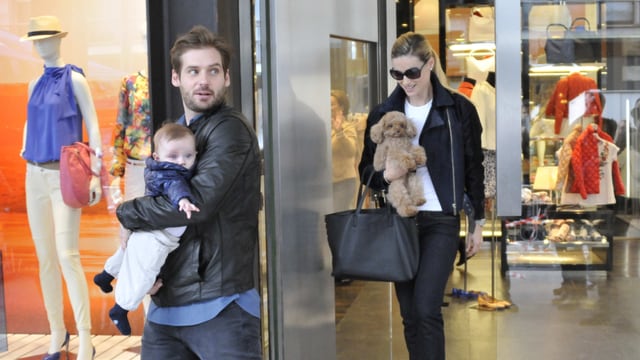 Tomaso Trussardi trägt Sole, Michelle Hunziker kommt im Hintergrund aus einer Boutique heraus. Tomaso Trussardi trägt Sole, Michelle Hunziker kommt im Hintergrund aus einer Boutique heraus.