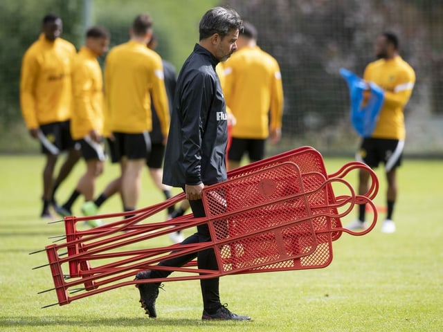 David Wagner trägt Trainingsutensilien auf den Platz David Wagner trägt Trainingsutensilien auf den Platz