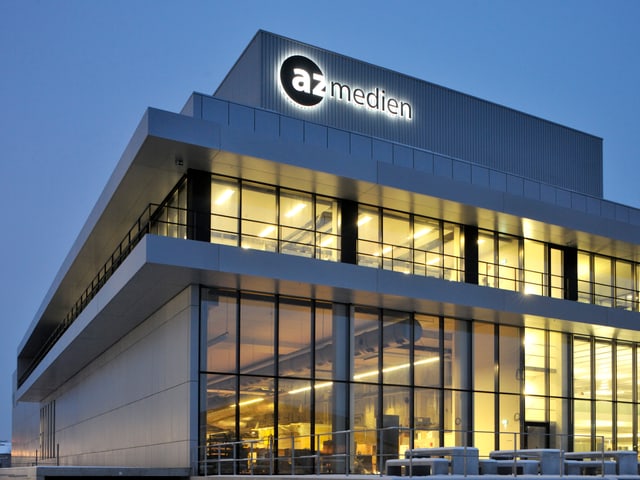 Beleuchtetes Haus mit AZ Medien Logo